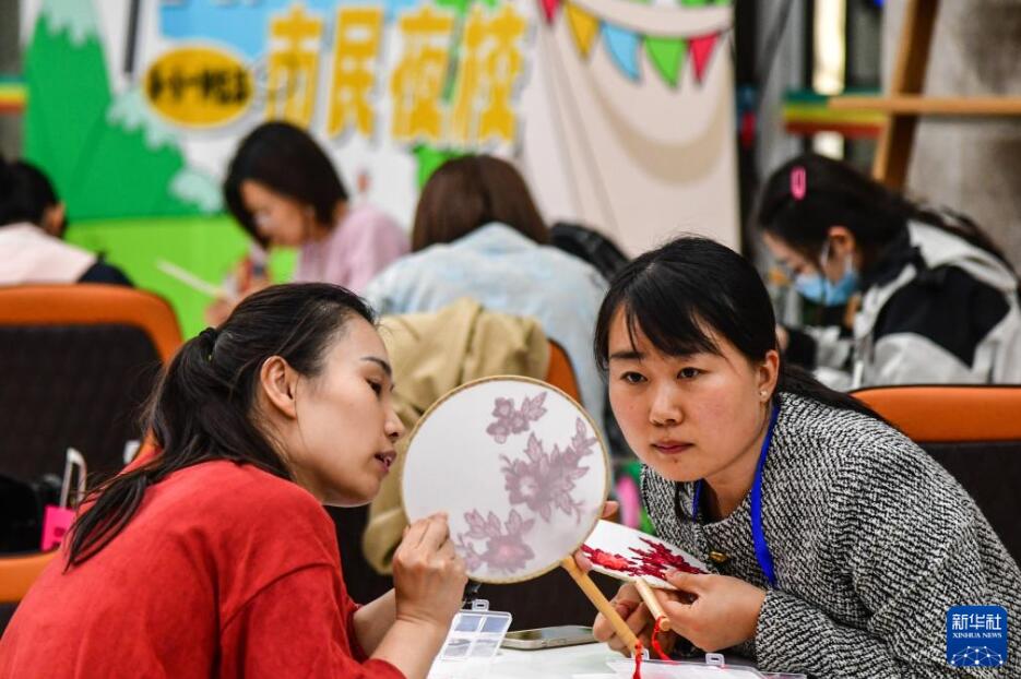 済南市図書館センター館でうちわの作り方を学ぶ受講者（4月23日撮影・朱峥）。