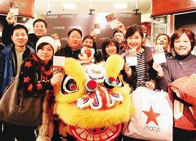 米国を訪れた中国人観光客。メイシーズ百貨店で、優待カードと買った商品を手に持って記念撮影。
