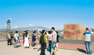 新疆維吾爾自治区阿拉山口で中国とカザフスタンとの国境の景色を楽しむ観光客たち