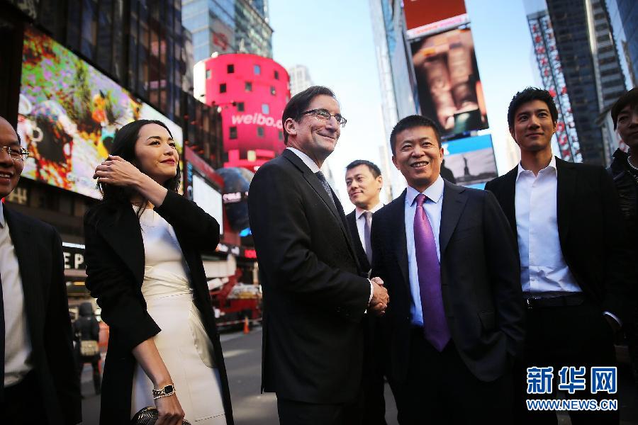 4月17日、米ニューヨークタイムズスクエアの ナスダックマーケットサイト近くで握手する新浪の曹国偉・董事長（右から2番目）とナスダックOMXグループCEOのRobert Greifeld（左から2番目）。新浪傘下のソーシャル･ネットワーキング・プラットフォームの微博（ウェイボー）公司（旧称「新浪微博」）は同日、米ナスダック市場に上場した。