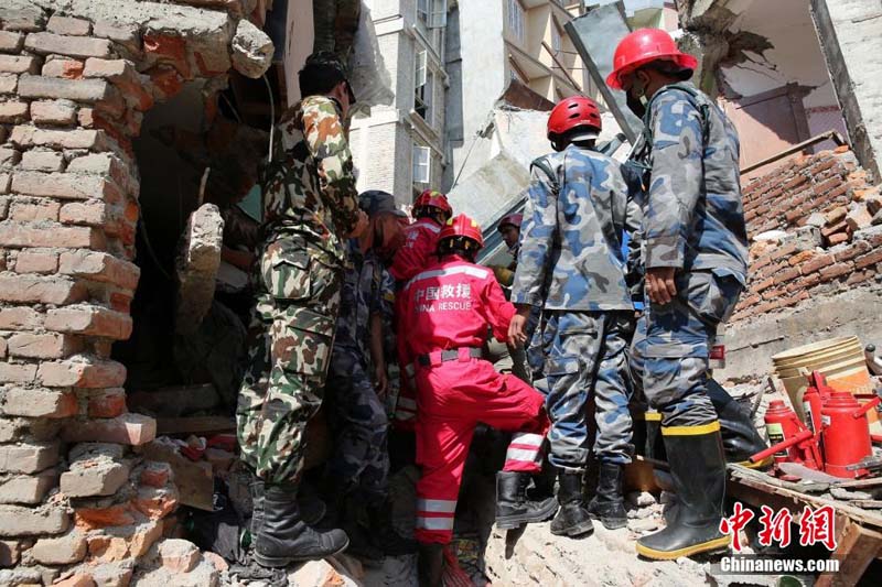 写真はカトマンズのある倒壊現場で瓦礫の下敷きになった人を救出する中国国際救援隊。