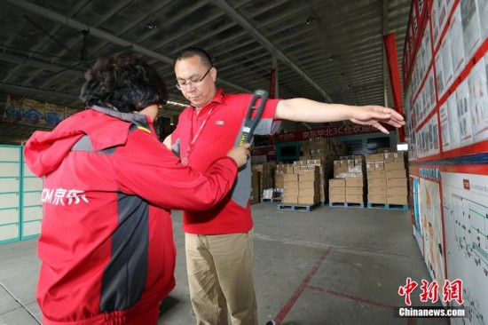 北京市通州区の馬駒橋鎮のある倉庫で、倉庫に出入りする関係者に対して厳しいセキュリティチェックを行う係員。倉庫の安全を保証するため、出入りする全ての人は携帯物の報告を行い、また係員が細かくチェックする。