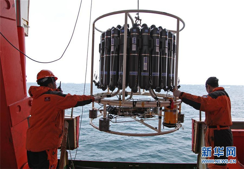 作業員が雪竜号の中部甲板から、CTD（塩分・水温・水深計）を南極半島沖に投入し、データと海水を収集。