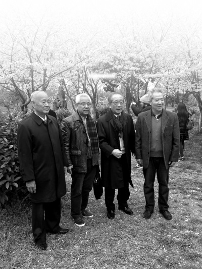 3月12日、堤角公園の桜の樹の下で記念撮影する4人。左から趙学東さん、朱漢順さん、村石久二さん、易望学さん。