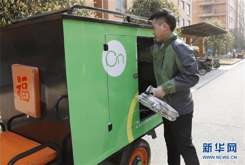 回収したちり紙を回収車に積み込む廃品回収作業員の朱孝軍さん＝3月28日