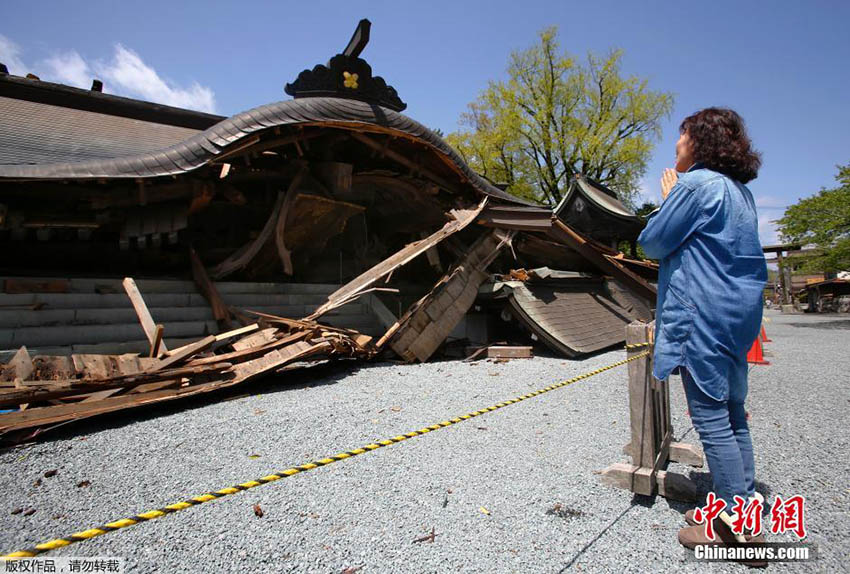 地震後の熊本、崩落した神社で手を合わせる現地の人
