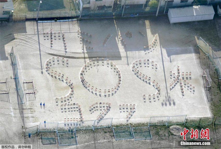 写真は現地時間4月17日、熊本県国府高校の運動場で、避難民がイスを並べて「カミ、パン、水、SOS」という救難サインを送っている。
