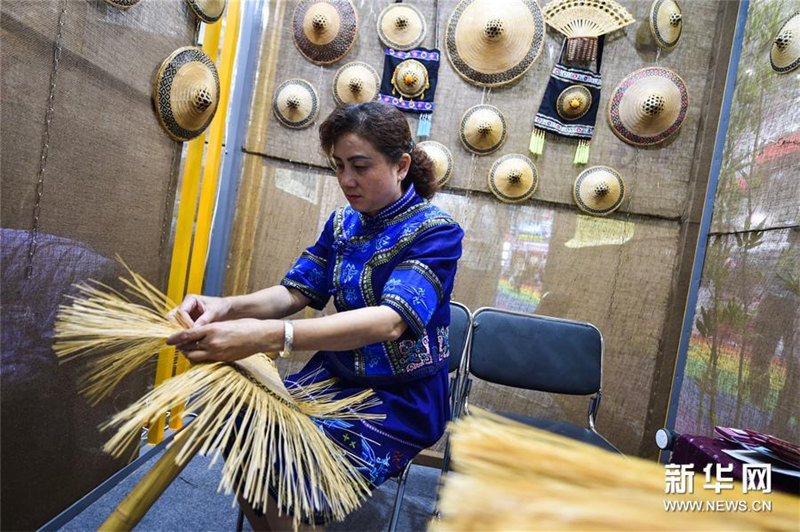 広西チワン族自治区のマオナン族の花竹帽の製作技術を披露する伝承人・譚素娟さん。