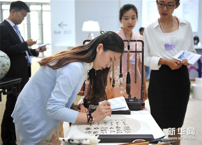 中国―天津展示エリアで書道をデモンストレーションするスタッフ。