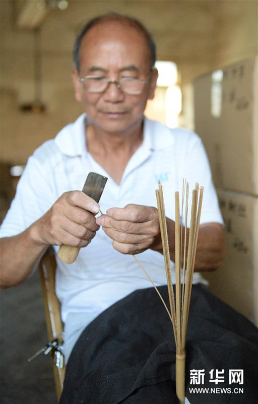 うちわの骨組みを作る広西チワン族自治区桂林市霊川県のうちわ職人・黄碩夫さん（7月6日撮影）。