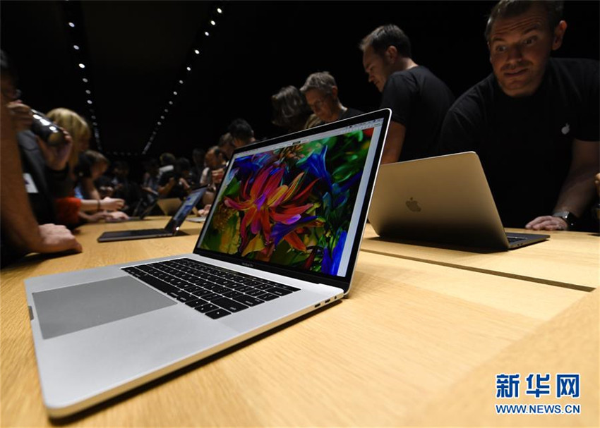 米カリフォルニア州クパチーノのアップル本社でスタッフがメディア向けに新型Macbook Proを紹介する様子（10月27日撮影）。
