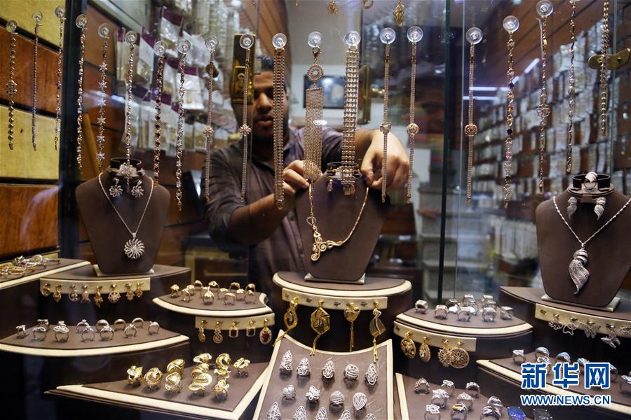 エジプトの首都カイロにある金を扱う店で、中国製金メッキの装飾品をディスプレイに並べる店員（撮影・アフマド・ゴマ）。