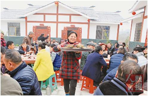 中国の農暦の新年をひかえたある日、四川省広安市のある村の15世帯の貧困家庭がいっせいに新たな住居に移住した。写真は、移住者らが自ら設けた宴席の様子。写真出典：人民日報