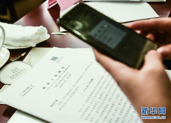 3月5日、北京会議センターで、記者が政府活動報告上の二次元コードをスキャンして情報を得た。
