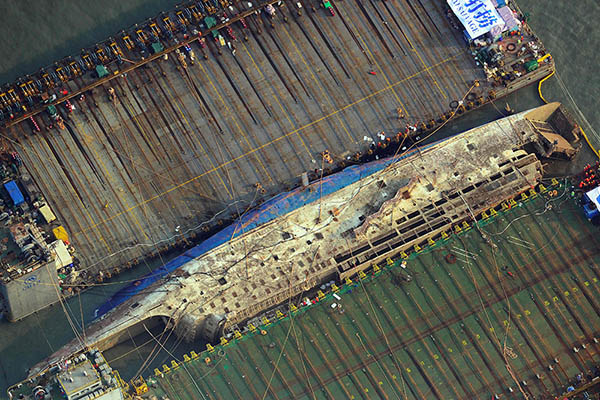 韓国「セウォル号」引き揚げ作業　船体が水面に姿現す