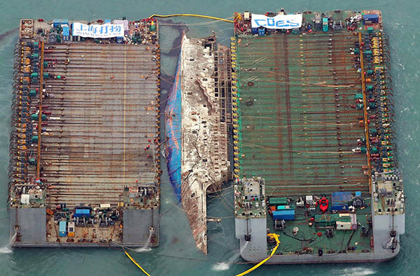 韓国「セウォル号」引き揚げ作業　船体が水面に姿現す