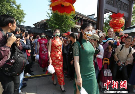 チャイナ・ドレス姿の「覆面」美女が颯爽と登場　ユニークな京劇マスクに熱視線