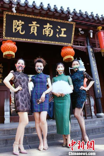 チャイナ・ドレス姿の「覆面」美女が颯爽と登場　ユニークな京劇マスクに熱視線