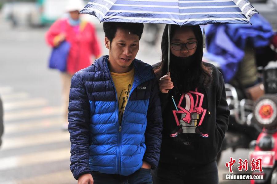 雨による気温低下で、厚着で出かける市民たち　昆明市