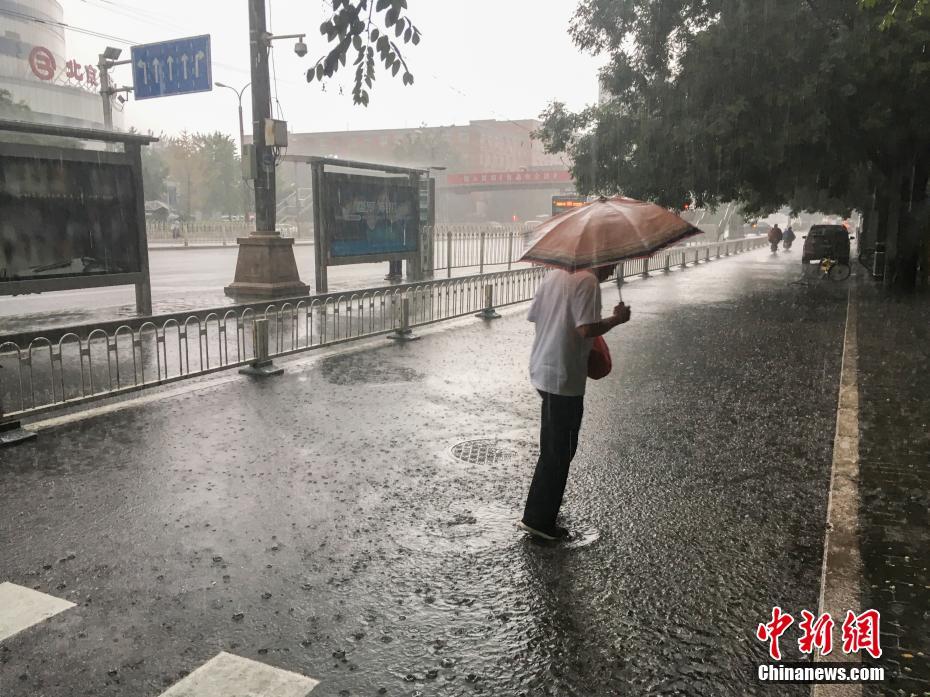 北京で早朝に大雨　雨の中を歩く市民たち