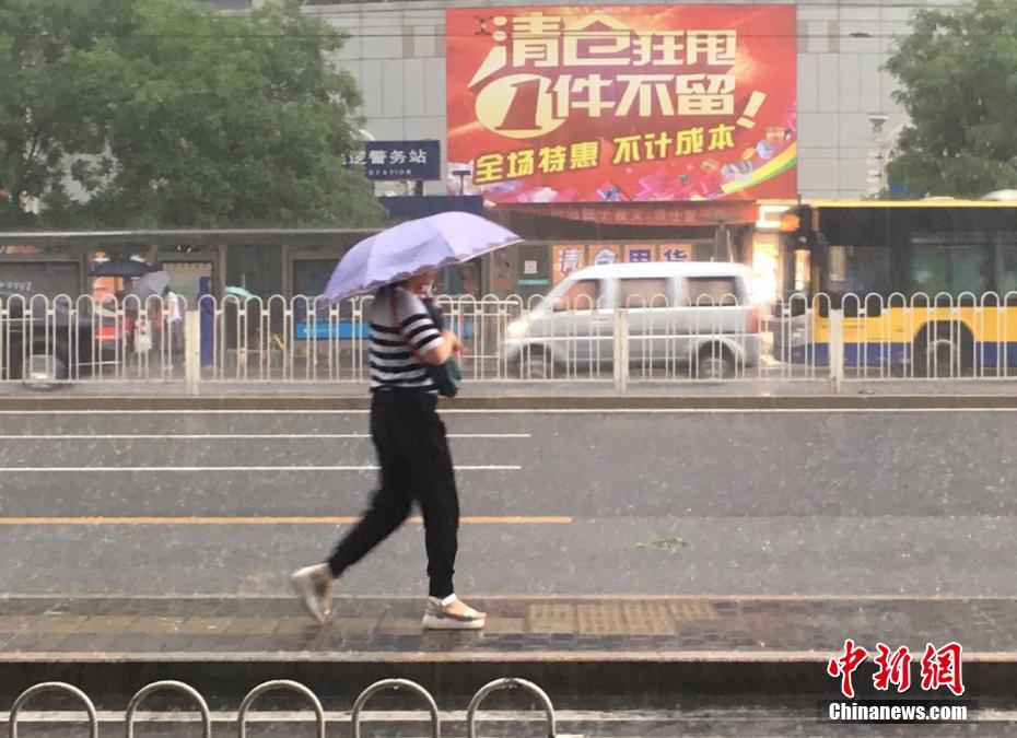 北京で早朝に大雨　雨の中を歩く市民たち