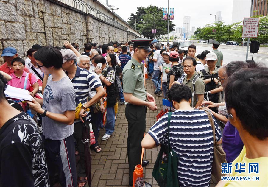 航空母艦「遼寧号」の見学チケットを求めて、雨の中並ぶ香港市民