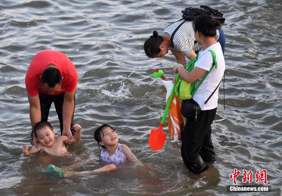 猛暑が続く厦門市、市民たちは海辺で水遊び