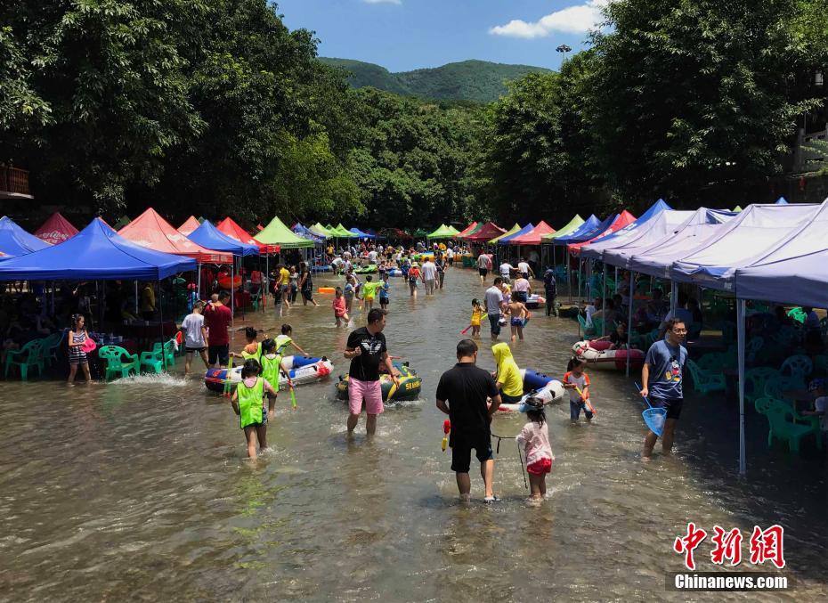重慶も酷暑に　水に足を浸けて麻雀楽しむ市民
