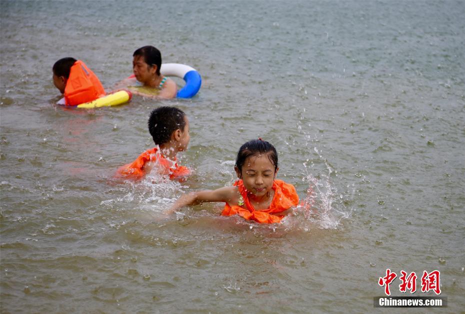 連日酷暑の広西チワン族自治区に「恵みの雨」、雨の中水遊びをする市民