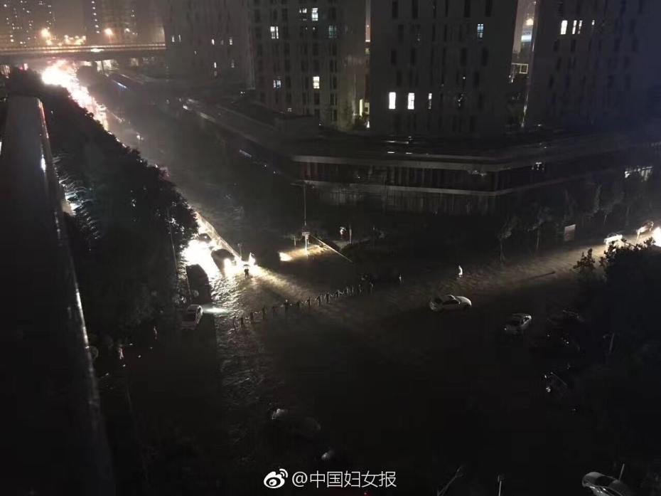 豪雨で道路冠水　人間の壁となって安全喚起を行う武装警官たち　北京