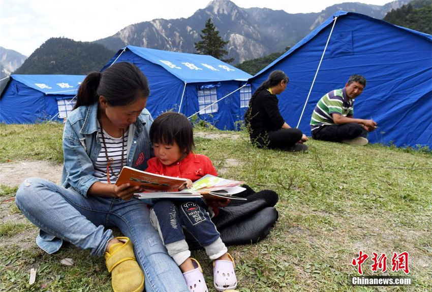 九寨溝景勝地荷葉寨のテント内で読書を読む人々（8月12日、撮影・安源）