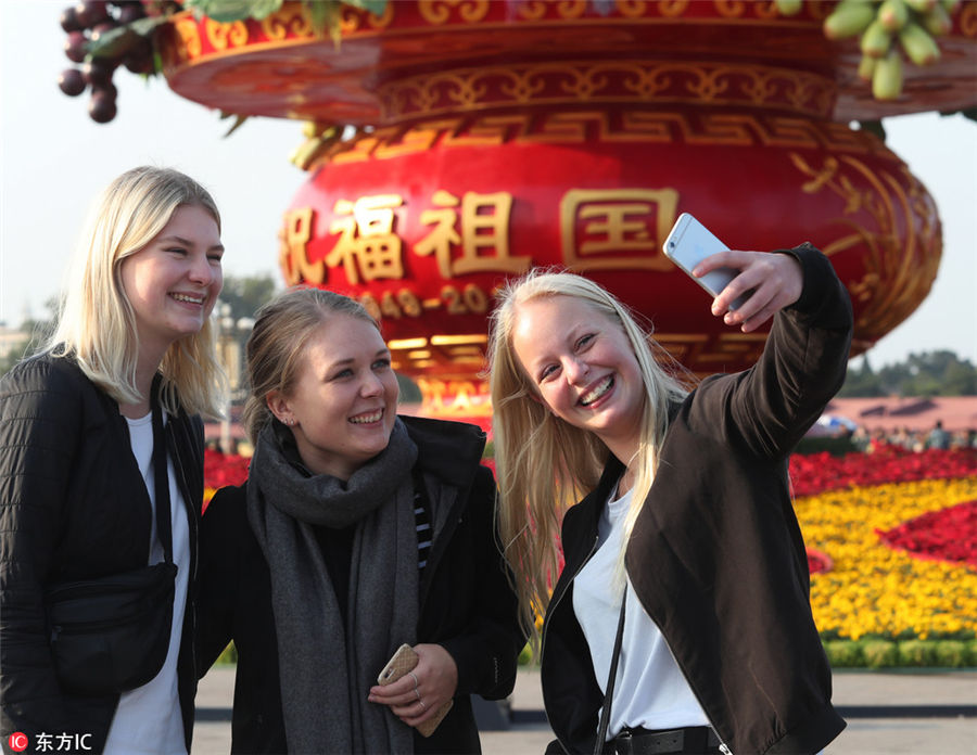 秋空をバックに天安門広場で記念撮影を楽しむ中国国内外の観光客たち