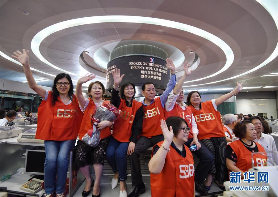 香港証券取引所の立会場で手を振り別れを告げる、赤いベストを着た担当者（10月27日、撮影・王申）。