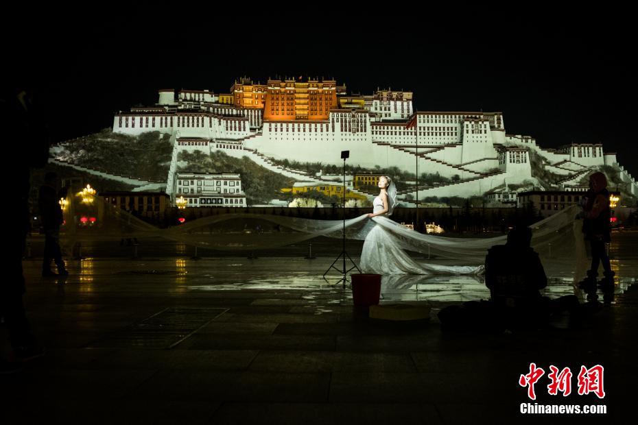 寒さをものともせず冬の夜にポタラ宮で撮影する観光客たち　チベット