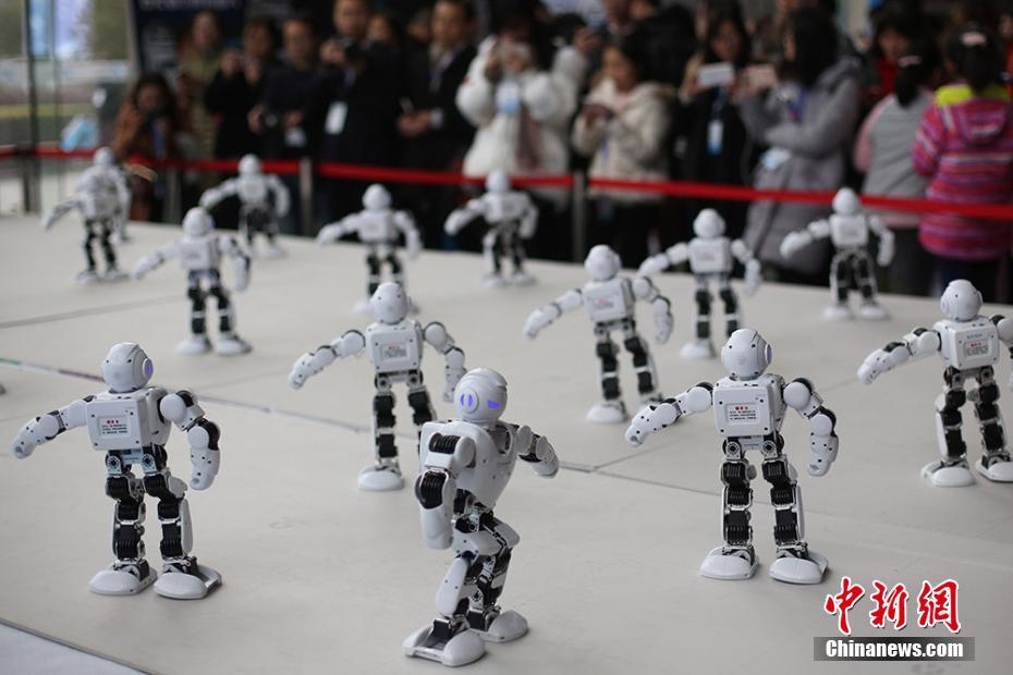 「ロボット」集団によるダンスパフォーマンするに惹きつけられる見学者（12月6日、撮影・泱波）。