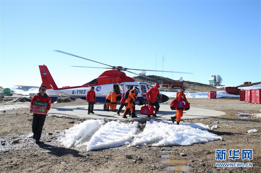 ヘリコプター「海豚」で先に中山基地に到着し、ヘリから物資を運び出す南極科学観測隊の隊員（12月27日、撮影・白国龍）。