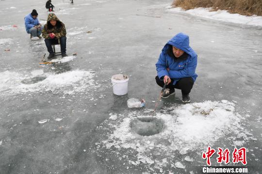 氷上で魚釣りを楽しむ釣り愛好家たち　山西省