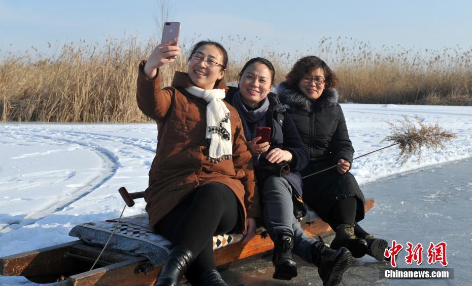 白洋淀湖を訪れ、記念撮影をする人々（撮影・韓氷）。