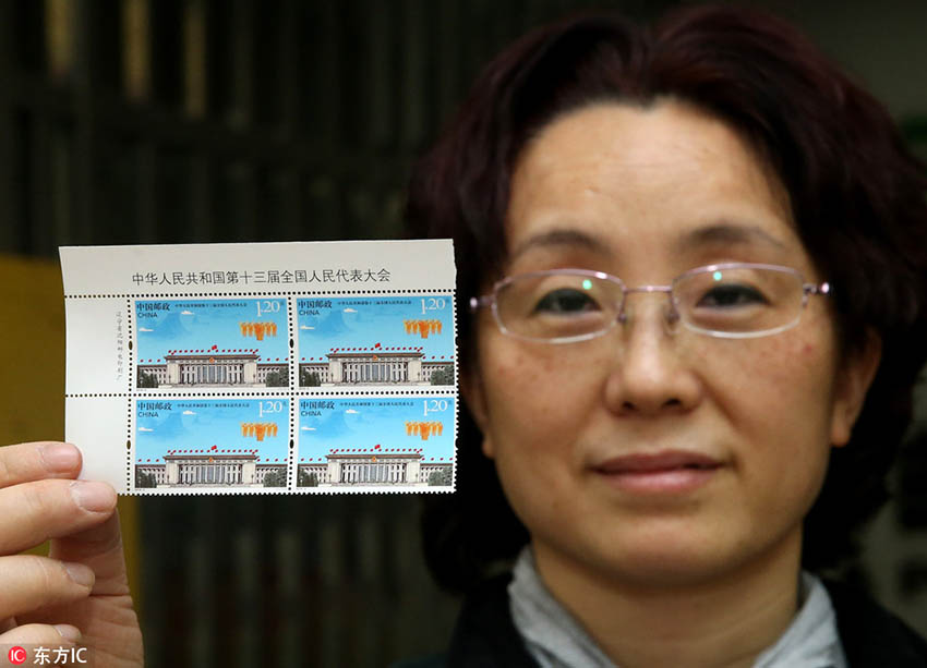 2018年3月2日、中国郵政集団公司眉山市支社の社員が、「中華人民共和国第13期全国人民代表大会」記念切手を紹介する様子。（撮影：張忠平）