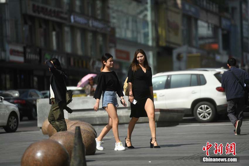 気温が30度近くまで上昇した重慶市　涼し気な装いで街中を歩く市民たち