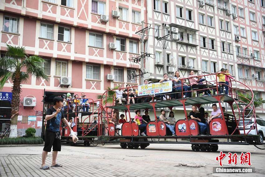 住宅用マンションの下をくぐって運行する観光ミニ列車　重慶市