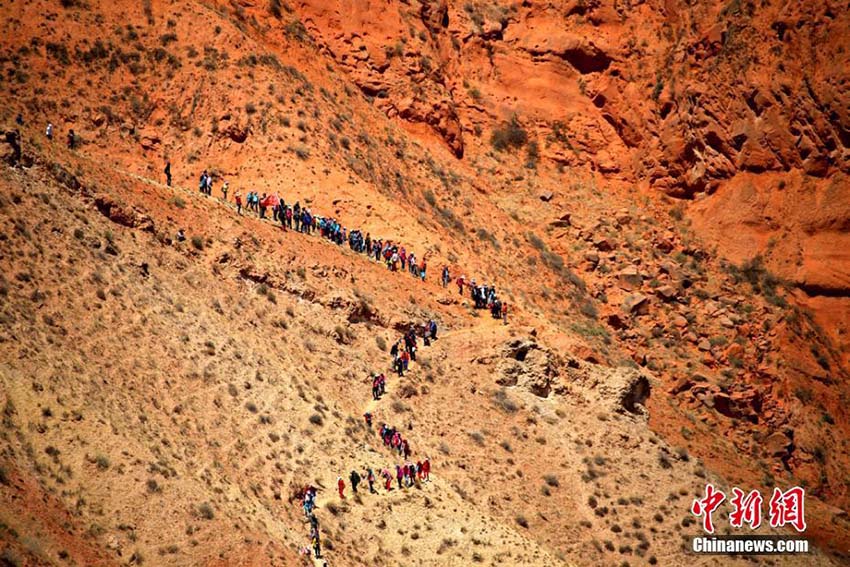 「鬼の顔」と呼ばれる赤い地肌続く丹霞地形を800人でハイキング　甘粛省