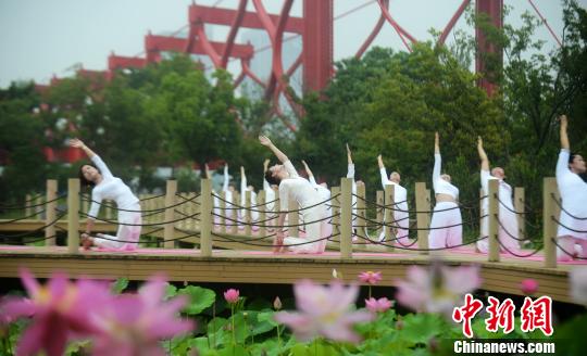 揚州市の景勝地でハスの花に囲まれながらヨガパフォーマンス