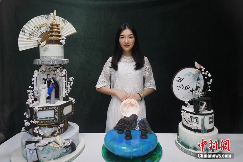 杭州文化をテーマとしたフォンダンケーキを展示するパティシエの陳瑶さん（7月5日、撮影・王剛）。