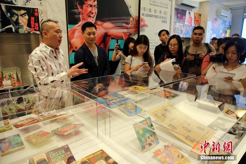 記者たちに展示品を紹介する香港地区のブルース・リー会の黄耀強会長（写真左側、撮影・洪少葵）。