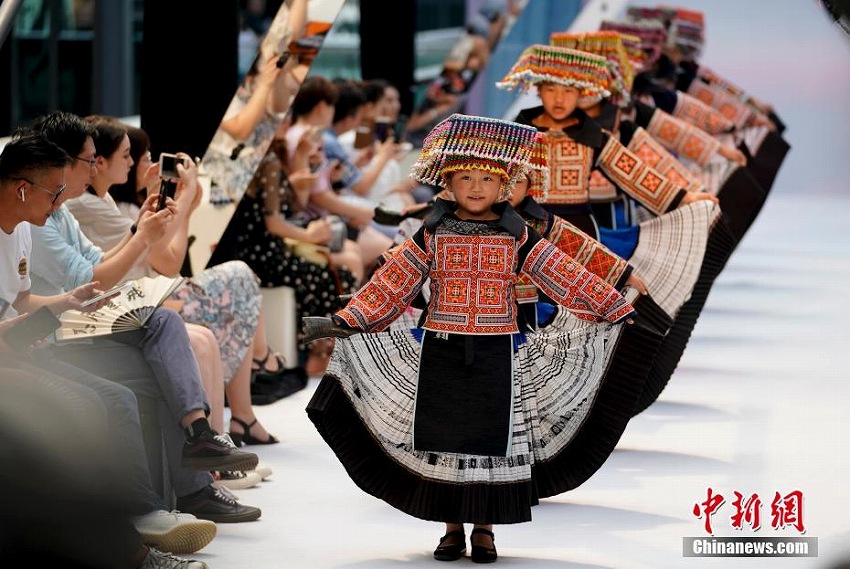 「山奥の市」の開幕イベントでダンスを披露する民族衣装を身に着けたミャオ族のお針子たち（撮影・杜洋）。
