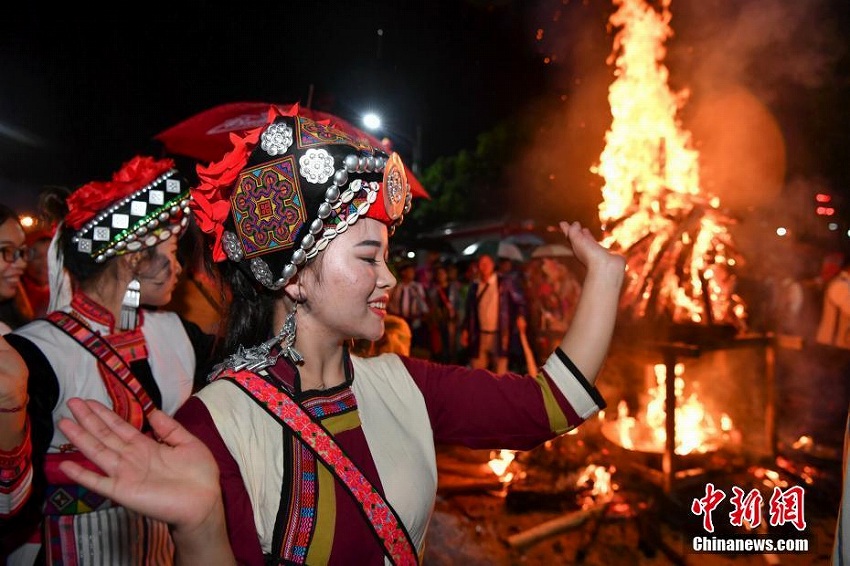 雨の中、「松明祭」を祝い歌って踊るイ族の人々　雲南省昆明市