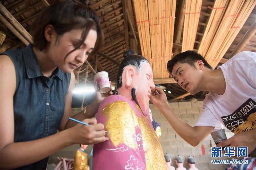 塑像を制作する許明笙さんと妻の朱悦さん（8月6日、撮影・翁忻暘）。