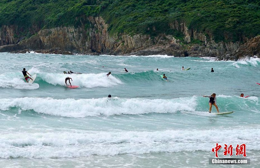 香港で強風警報、高波を楽しむサーファーたち