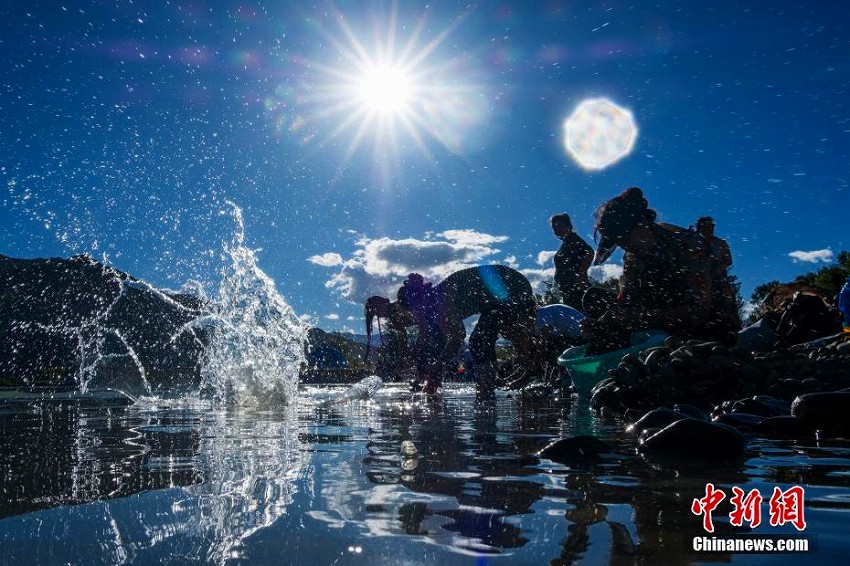拉薩河のほとりで沐浴する蔵族の人々（撮影・何蓬磊）。